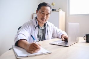 Arzt schreibt etwas auf